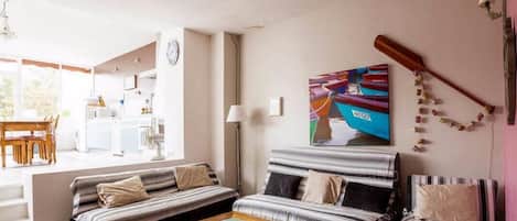 Una sala de estar con un sofá, una mesa de centro y un cuadro en la pared.