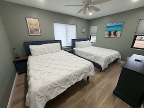 A hotel room with two beds, a ceiling fan, and artwork on the walls. - Sunset Lake Haven |Hot Tub | Inflatables | Arcade (New Lisbon)
