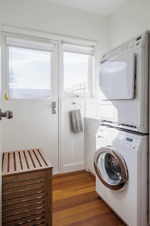 A laundry room with a washing machine, a dryer, and a wooden drying rack. - Sea Quinn Escape Steps to Dromana Beach and Dining (Dromana)