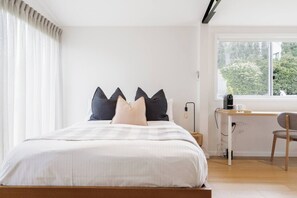 Ein Schlafzimmer mit einem Bett, einem Schreibtisch und einem Stuhl.