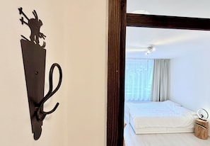 A room with a bed, a wooden nightstand, and a wall-mounted light fixture. - White Peak - stylish alpine base for two in charming Bovec (Bovec)