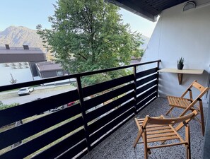 A balcony with a view of a mountain, a parked car, and a building with a sloped roof. - White Peak - stylish alpine base for two in charming Bovec (Bovec)