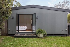 A modern, single-story building with a large sliding glass door entrance leading to a bedroom. - Pavilion Verde Designer Retreat near Rosebud Beach (Rosebud)