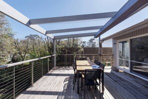 A wooden deck with a table and chairs, a glass door, and a metal railing. - Melrose Nest Peaceful Mount Martha Stay near Beach (Mount Martha)