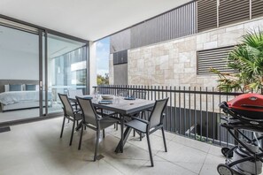 A balcony with a dining table, chairs, a grill, and a view of the city. - Bayside Calm Walk to Mornington Foreshore and Dining (Mornington)