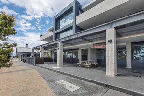 A modern building with a storefront labeled 'PARKVUE' and a 'GELATO' sign, featuring a covered outdoor seating area. - Bayside Calm Walk to Mornington Foreshore and Dining (Mornington)