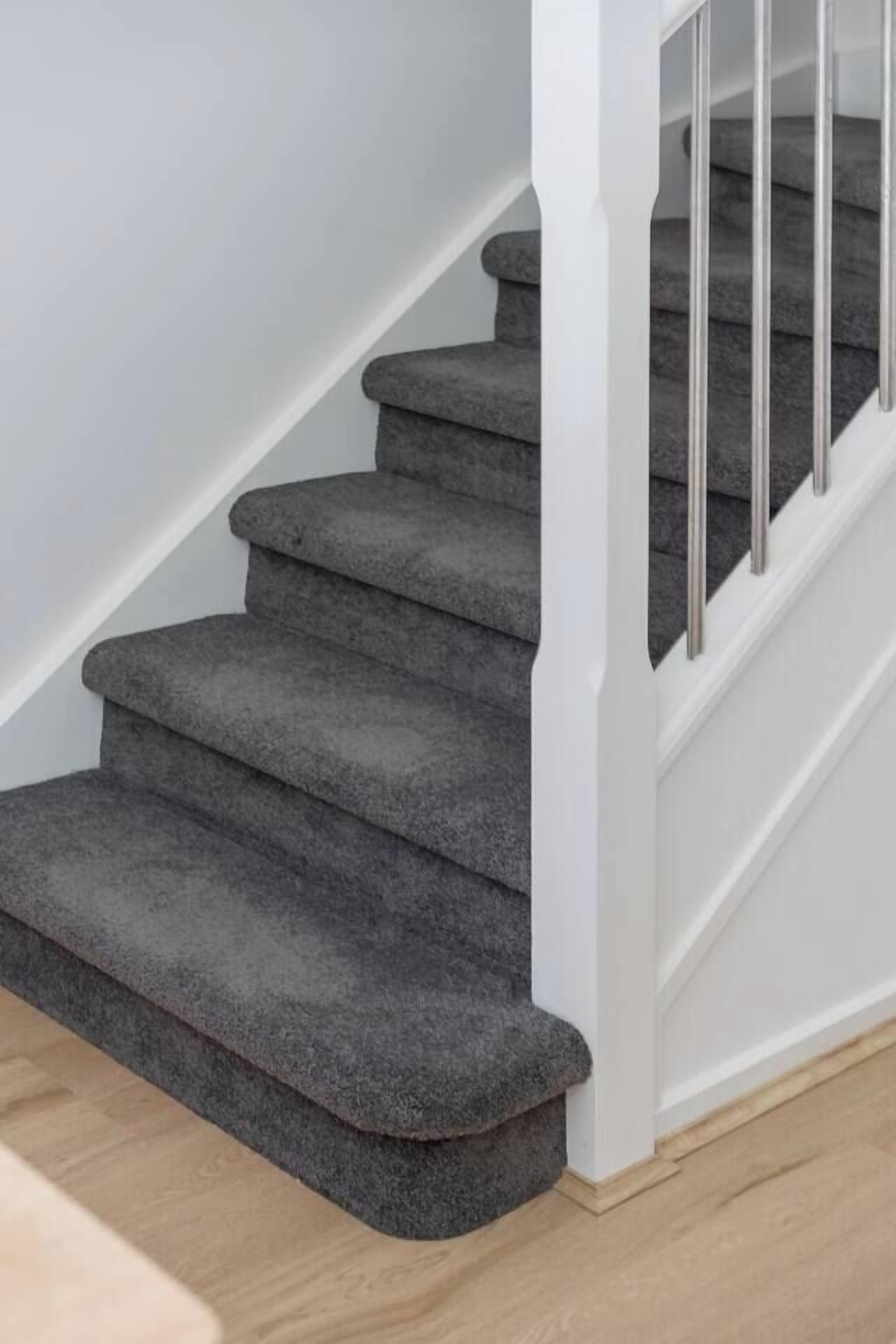 A staircase with carpeted steps and a white handrail.