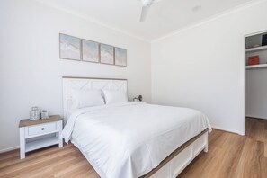 Ein Schlafzimmer mit einem Bett, einem Nachttisch, einer Kommode und einem Kleiderschrank.