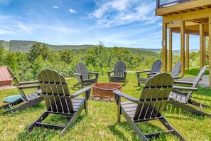 A deck with Adirondack chairs and a fire pit, overlooking a scenic landscape. - Large Luxury 6br Okemo Home | Hot Tub | Mtn View (Ludlow)