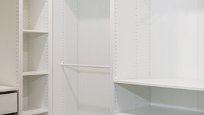 Vestidor con repisas abiertas, barra para colgar ropa y un cajonera empotrada.