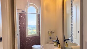 Une salle de bain avec un grand miroir, une baignoire, un lavabo et des toilettes.