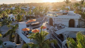 A resort with multiple buildings, outdoor seating areas, and palm trees. - Cabo San Lucas Castle · Rooftop Sea Views (Cabo San Lucas)