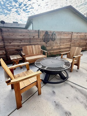 Eine Terrasse im Freien mit einem runden Tisch und sechs Holzstühlen.