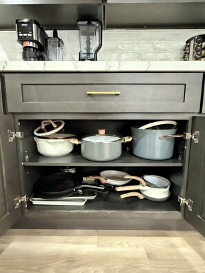 A kitchen with a built-in coffee maker, a blender, and a cabinet with pots and pans. - The Modern + Cabin Retreat+ Grill (Stockton)