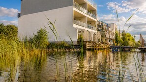 Un bâtiment moderne doté d’un toit plat, de nombreux balcons et offrant une vue sur le front de mer.
