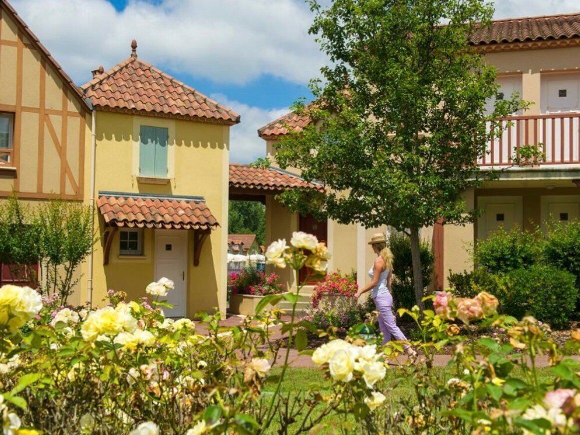 Un quartier résidentiel avec des maisons aux toits en tuiles, et une personne qui marche au premier plan.