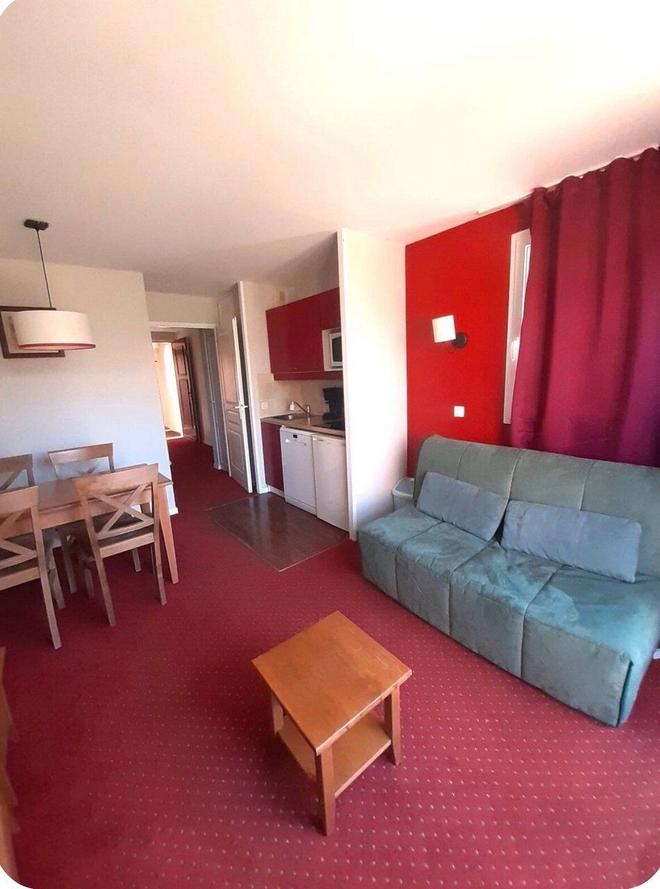 A compact living space with a dining area, kitchenette, and a sofa.