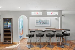 Un espace bar avec un comptoir et quatre tabourets.