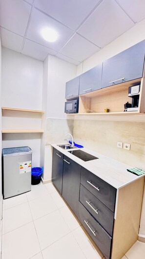A compact kitchen with a refrigerator, sink, and cabinets. - Apartment, downtown Oran (Oran)