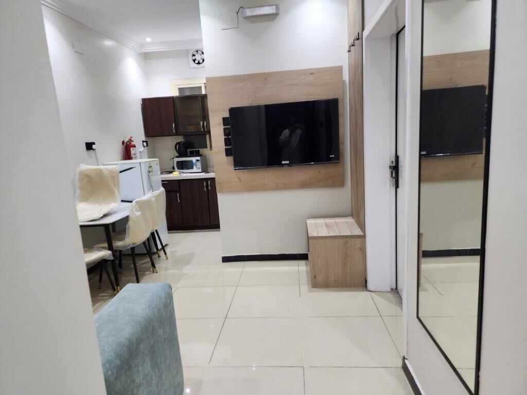 Uma cozinha moderna com micro-ondas, armários e uma TV de tela plana na parede.