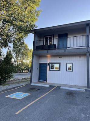 A two-story building with a blue door, a balcony on the upper floor, and a parking space with a handicapped symbol. - Townhome with Mount Massive, Massive View! (Leadville)
