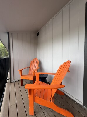 A wooden deck with two orange Adirondack chairs and a small round table. - Townhome with Mount Massive, Massive View! (Leadville)