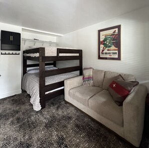 A bunk bed with a white mattress and a sofa with a leopard print rug. - Townhome with Mount Massive, Massive View! (Leadville)