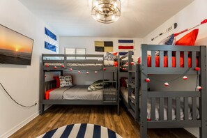 Habitación con literas y vista al atardecer, una bandera y un letrero de bienvenida.