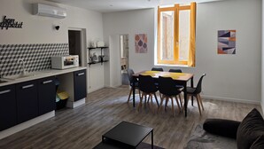 A compact living space with a kitchenette, dining area, and a large window.