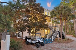 A building with a staircase leading to a deck, surrounded by trees and a golf cart parked nearby. - Close to Beach | Private Pool | Games | LSV (Santa Rosa Beach)