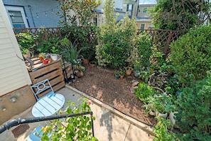 Ein Garten mit verschiedenen Pflanzen und einem kleinen Tisch mit Stühlen.
