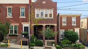 A row of brick townhouses with front porches, a visible address number, and a small garden area. - Charming 3BR East Falls Home with Fenced Yard & Office (Philadelphia)