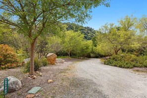 A gravel path leading through a wooded area with trees and rocks. - Riverfront Paradise at RedRock Villa (Three Rivers)