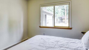 A bedroom with a single bed, a window with a wooden frame, and a view of the outside. - Tahoe Town & Lake Retreat - Near Tahoe Keys (South Lake Tahoe)