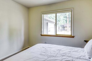 A bedroom with a single bed, a window with a wooden frame, and a view of the outside. - Tahoe Town & Lake Retreat - Near Tahoe Keys (South Lake Tahoe)