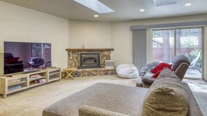 A living room with a fireplace, a television, and a sofa. - Tahoe Town & Lake Retreat - Near Tahoe Keys (South Lake Tahoe)