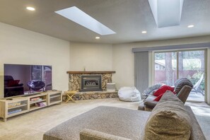 A living room with a fireplace, a television, and a sofa. - Tahoe Town & Lake Retreat - Near Tahoe Keys (South Lake Tahoe)
