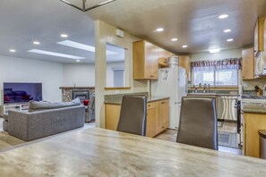 A compact living space with a dining area, kitchen, and a seating area with a fireplace. - Tahoe Town & Lake Retreat - Near Tahoe Keys (South Lake Tahoe)