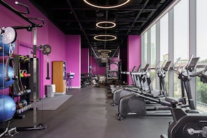 A gym with exercise equipment, weightlifting stations, and a large window providing a view of the outside. - Wink Hanoi Westlake, Unscripted by Hyatt - 24 Hours stay (Hanoi)