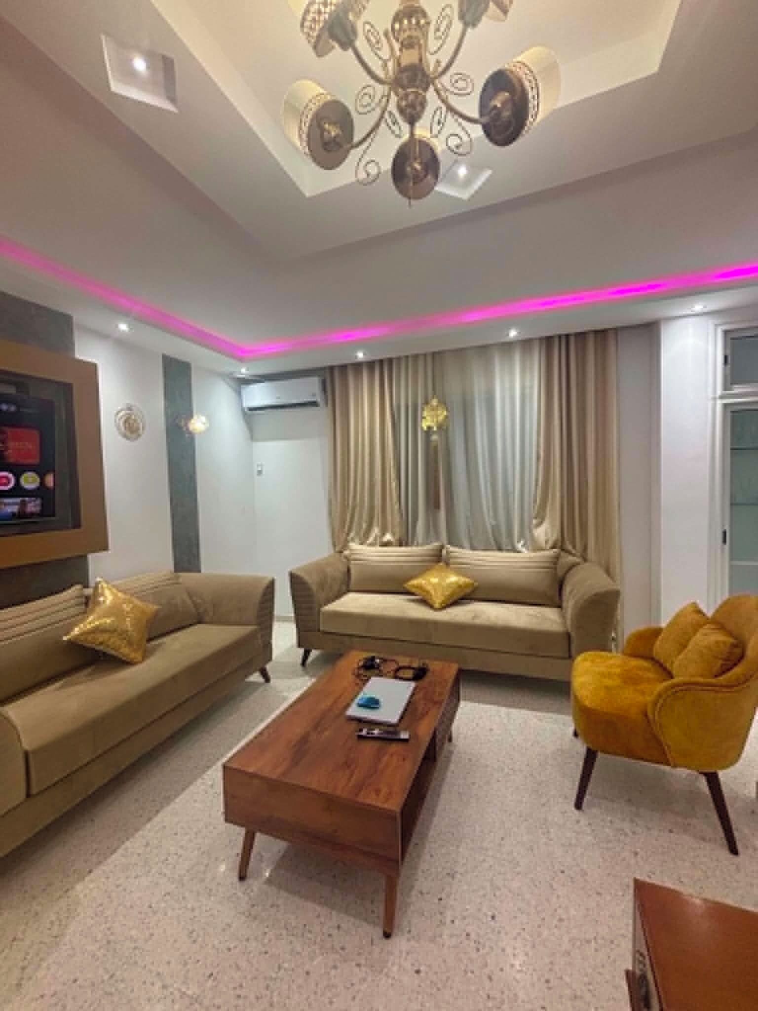 A modern living room with a sofa set, a coffee table, and a yellow armchair.