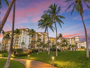 A multi-story hotel with balconies, surrounded by palm trees and a well-maintained lawn. - Beach Villas Ko Olina ~ Stunning Ocean & Beach Views from 3 Lanais ~ Corner Unit (Kapolei)
