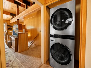 A laundry room with two stacked front-loading washing machines. - The Moonridge Escape (Big Bear Lake)