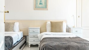 A hotel room with a bed, a bedside table, a nightstand, a drawer unit, and a framed picture on the wall. - Sam65i Central 2 Bed Penthouse in Nueva Andalucia (Marbella)