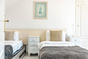A hotel room with a bed, a bedside table, a nightstand, a drawer unit, and a framed picture on the wall. - Sam65i Central 2 Bed Penthouse in Nueva Andalucia (Marbella)