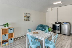 A compact kitchen with a dining area, a bean bag, and a small bookshelf. - Private Beach Access, Ocean Views, Hot Tub, Balcony, Brand New Furnishings, $300 in Free Tickets! (St. Augustine)