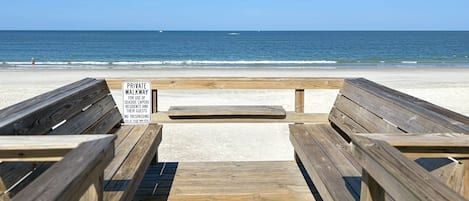 Une promenade en bois mène à une plage, et une pancarte indique qu’il s’agit d’un sentier privé réservé aux résidents et à leurs invités.