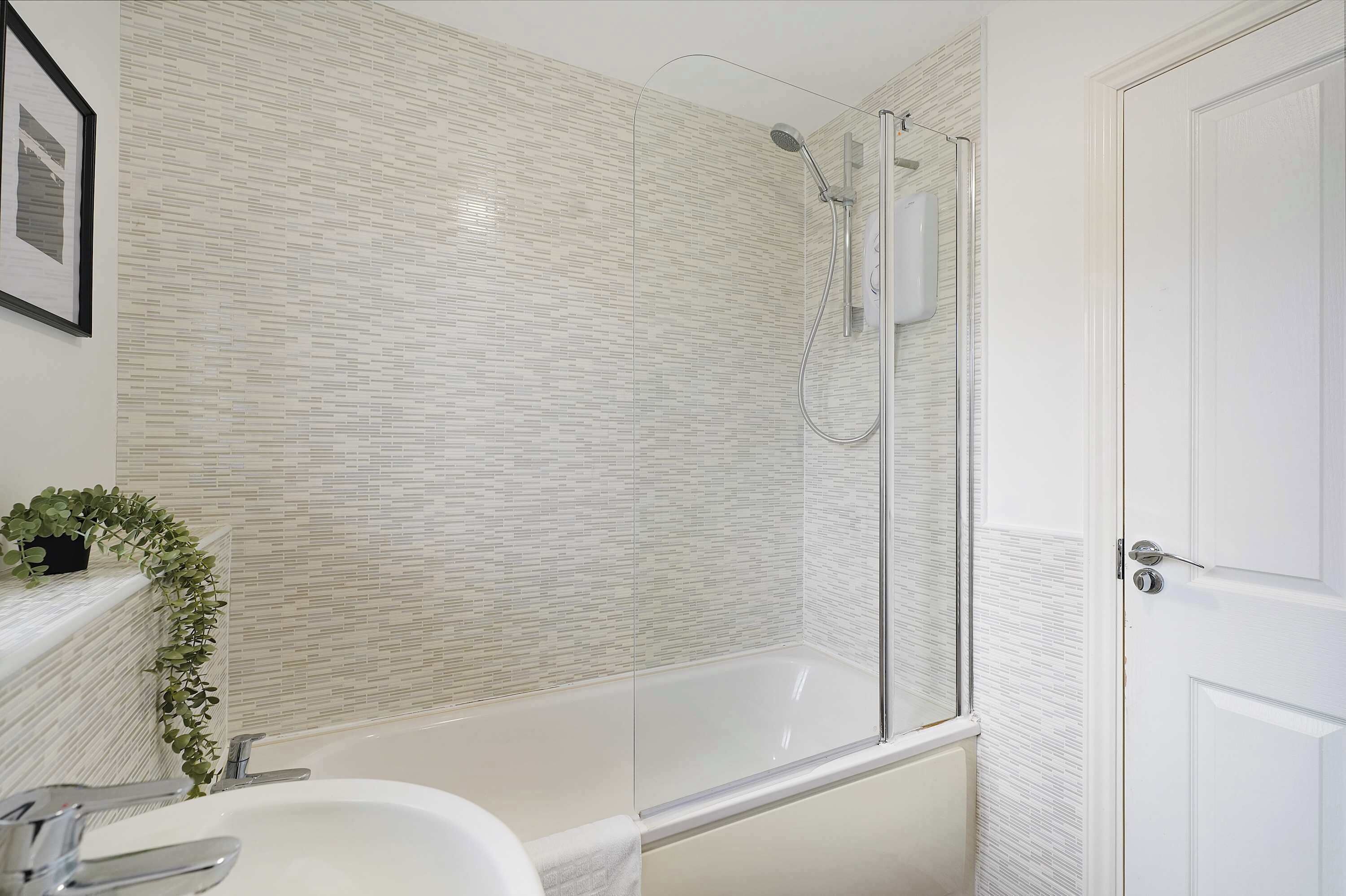 A bathroom with a bathtub, a shower, and a sink.