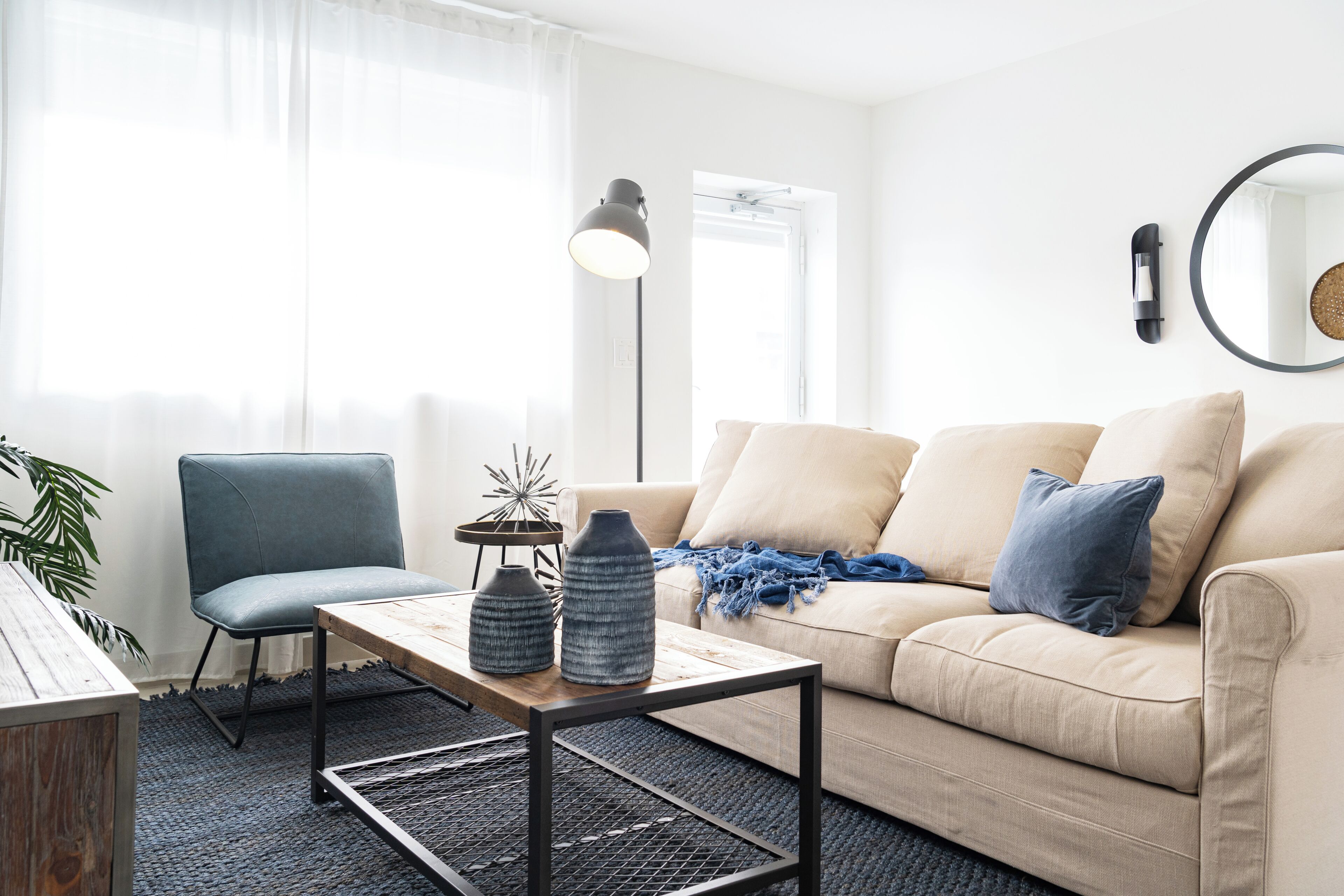 A modern living room with a sofa, a chair, a coffee table, and a floor lamp.