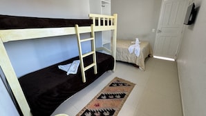 A bunk bed room with a ladder, a small bedside table, and a patterned rug. - Mansion in Maracaipe, 100 meters from the sea, Jacuzzi, Swimming pool, Games room. (Ipojuca)