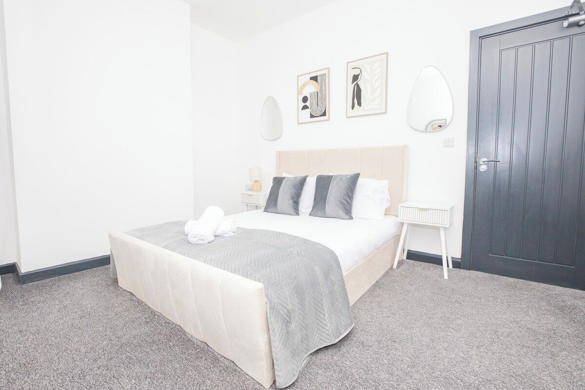 Une chambre d’hôtel avec un lit, des tables de chevet, une armoire et des œuvres d’art accrochées au mur.